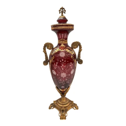 "گلدان کنار سالنی با بدنه شیشه‌ای شفاف و پایه‌های زاماک بادوام."